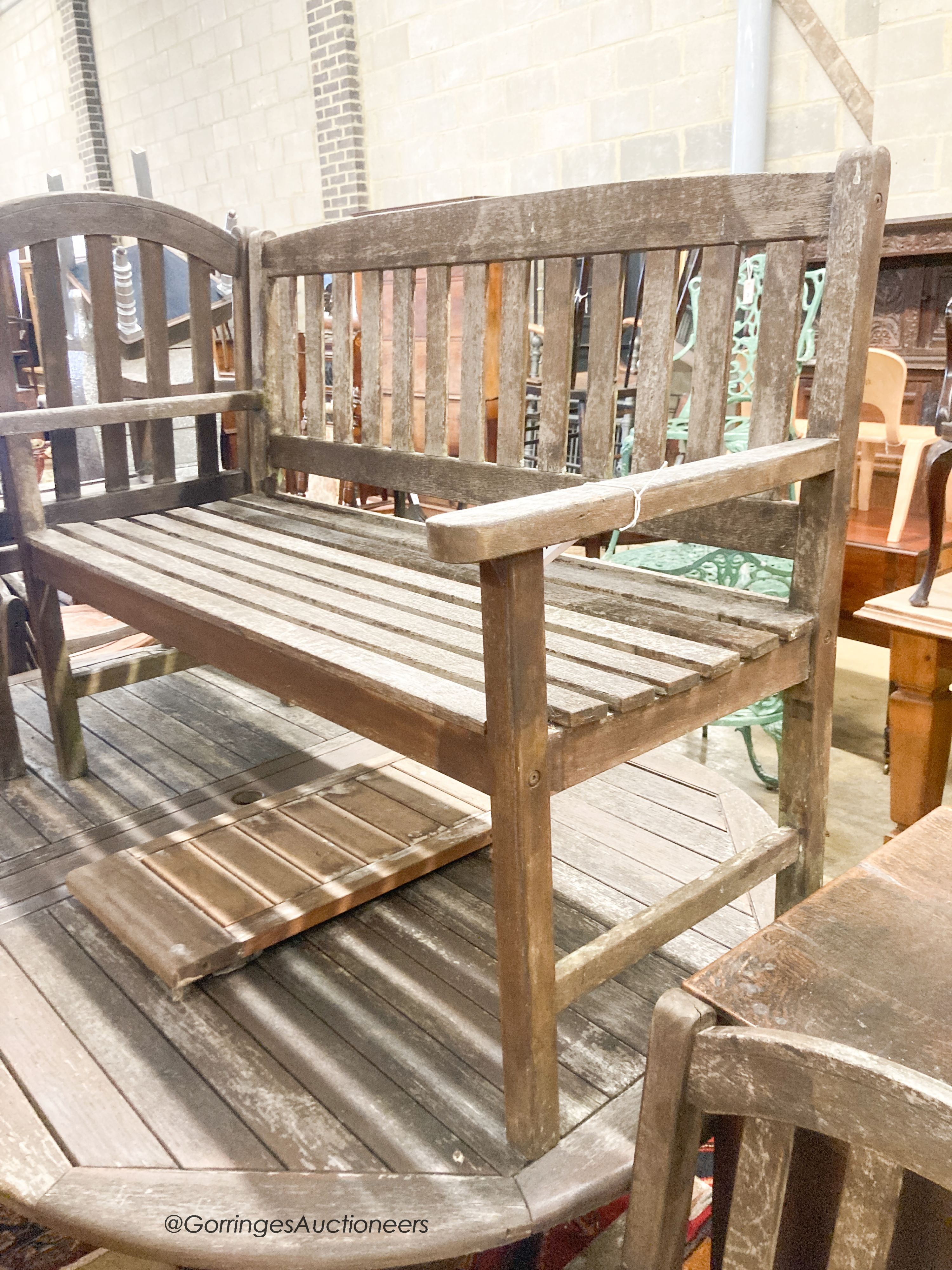 A weathered teak extending garden table, length 190cm, depth 120cm, height 74cm a bench and four weathered teak armchairs